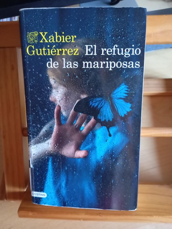 Portada del 'El refugio de las mariposas', con una mariposa oscura sobre fondo neutro y tipografía sobria