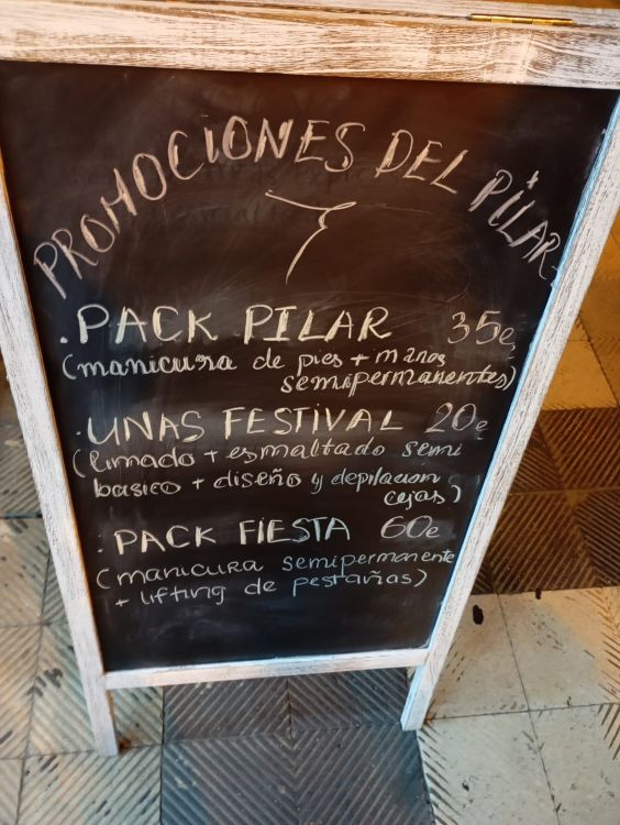 Cartel promocional de belleza en Zaragoza con la expresión absurda 'manicura de pies' escrita en tiza sobre pizarra