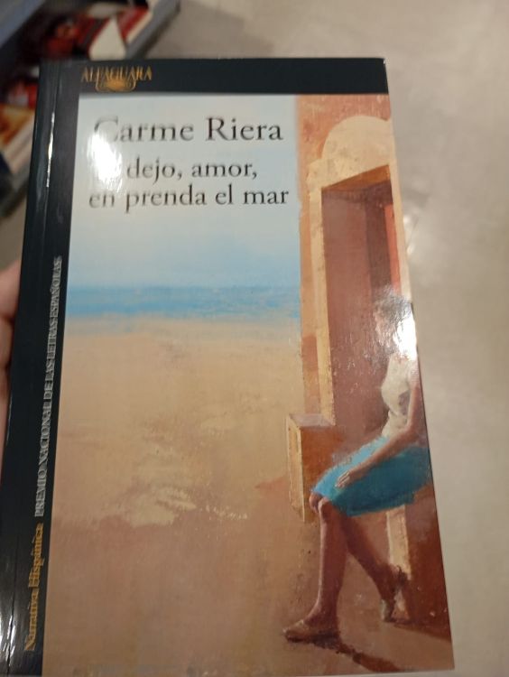 Te dejo, amor Portada de 'Te dejo, amor, en prenda el mar' de Carme Riera, en la que se muestra una figura sentada frente al mar, en una escena serena y contemplativa.
