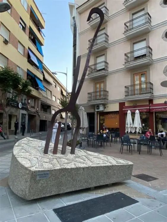 Escultura urbana de un tenedor curvado incrustado en piedra, homenaje a la tortilla de patata en Villanueva de la Serena