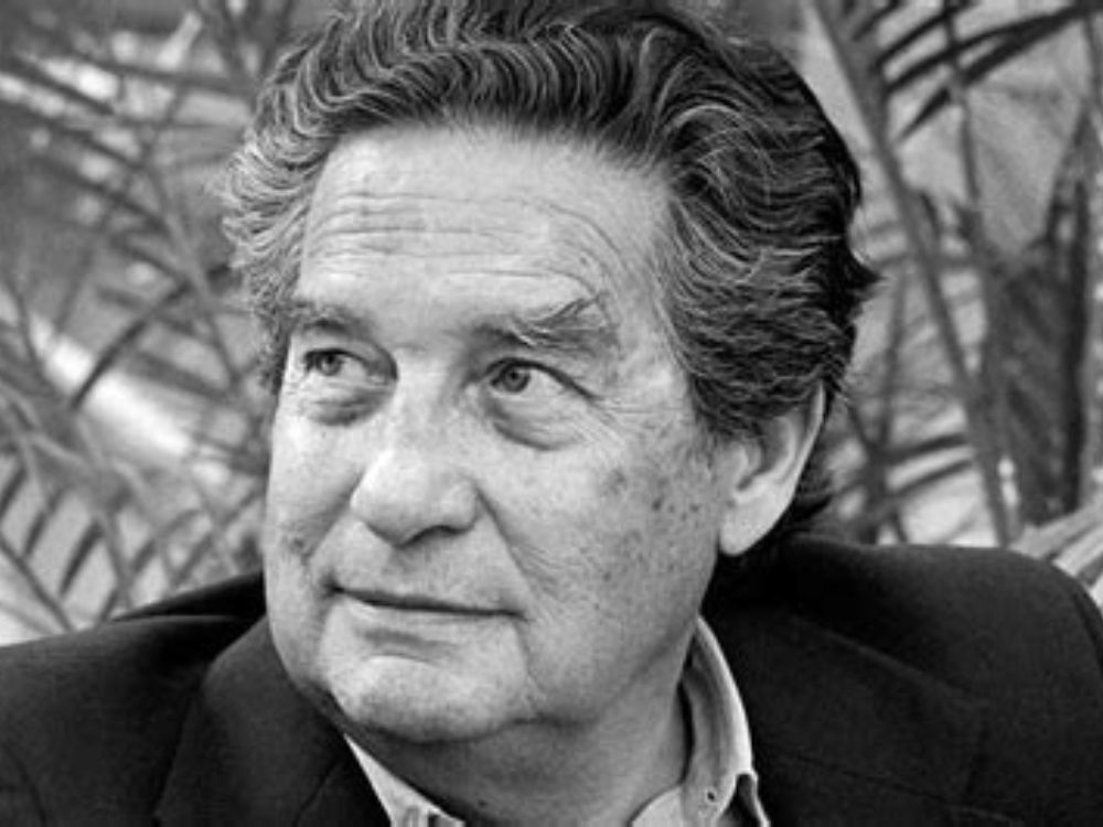 Retrato en blanco y negro de Octavio Paz con cabello ondulado y canoso, vestido con camisa y chaqueta, mirando ligeramente hacia un lado